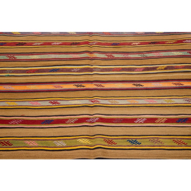 Beautiful Vintage Kilim hand-knotted wool rug with a multicolor accents in an all-over geometric stripe design. This rug...