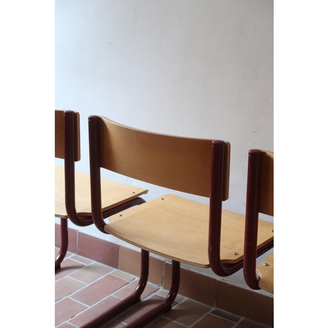 A set of four Scandinavian cantilever chairs, stamped Randers Møbelfabrik, 1960s. Moulded beech shells on a red lacquered...