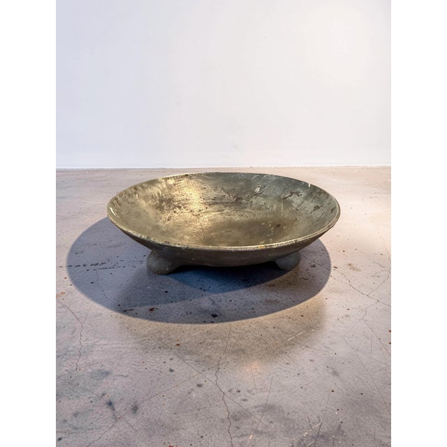 A sculptural mid-century brutalist centerpiece bowl featuring a shallow flared vessel supported by three raw cast...