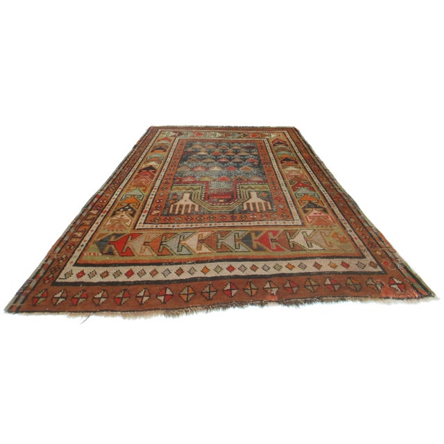 Offered is a beautiful Russian area rug. This rug is composed of hand knotted wool and features tones of rust, brown, and...