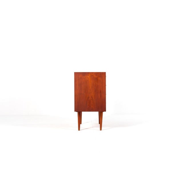 A stunning mid-century modern dresser designed by Kai Kristiansen, crafted in Denmark from rich teak wood. This elegant...