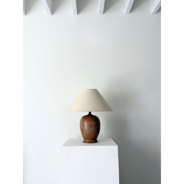 A weighty Italian table lamp in lime washed wood. This 20th century accent light has a tactile ovoid shape and is formed...