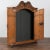 Extensive hand carved details abound in this small scale two door pine armoire. Note the carved tassels, central cherub...