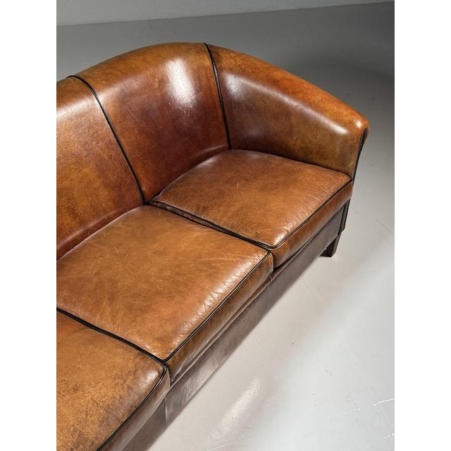 Spacious 3-seater sofa. Fully upholstered in high-quality sheepskin leather with loose cushions. Finished all around with...