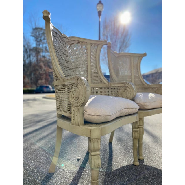 Gorgeous pair of double caned wing back chairs with carved arms and legs, cane seats and removable linen cushions. The...