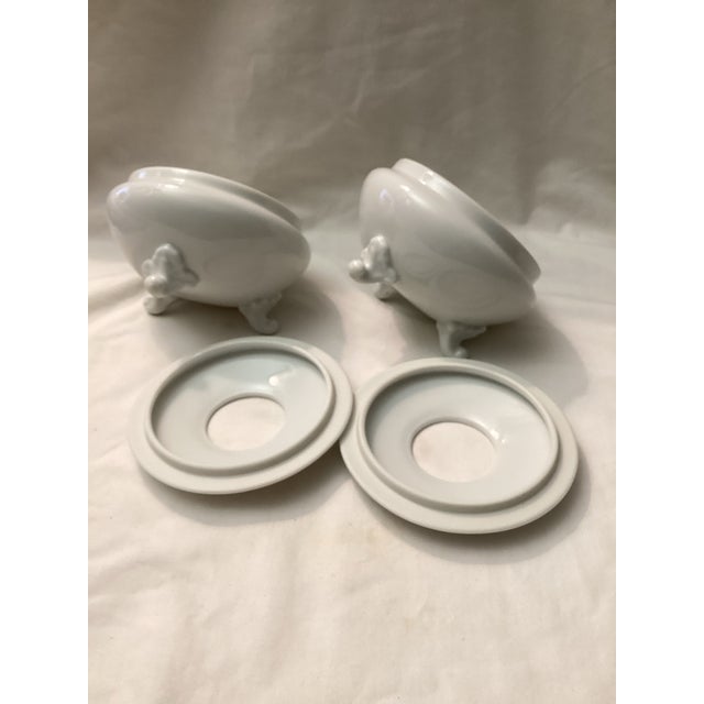 Elegant pair of white porcelain footed bouillon cups styled after Lemogues design. each features, graceful tripod style...