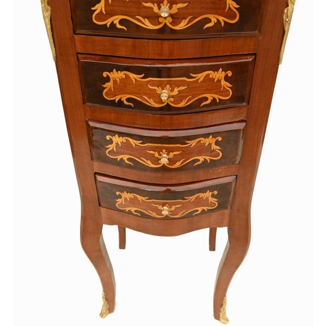 A fine pair of French bedside cabinets in the Louis XV style crafted in kingwood and richly decorated with intricate...