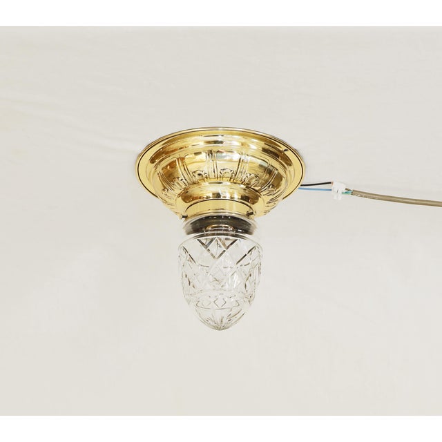 Art Nouveau ceiling lamp, circa 1915. Brass, geometrically embossed. Original clear glass shade with cut glass decoration....