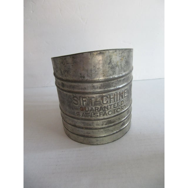 Two vintage flour sifters. One marked "sift-chine" with a green metal handle, the other a pale yellow with green and...