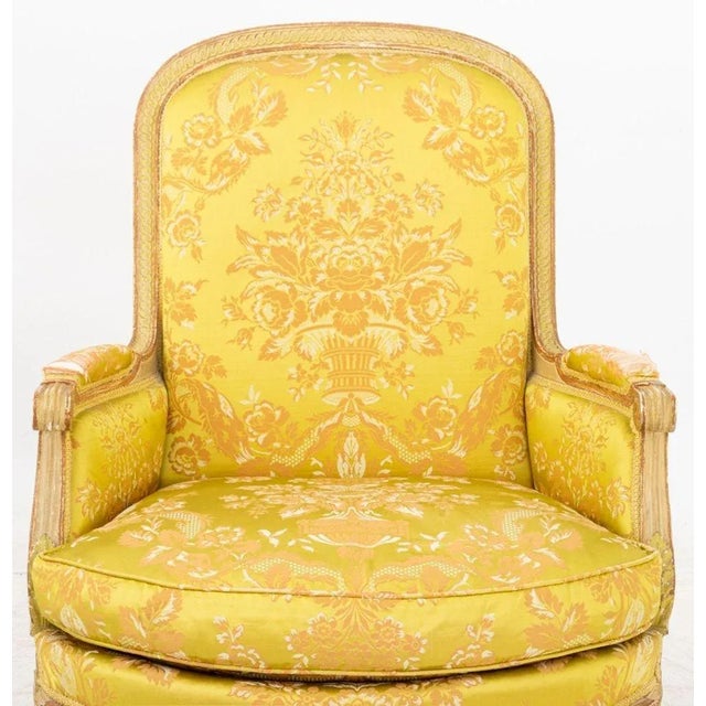 Louis XVI Style Painted Bergere, 19th century, in green, gray, and yellow floral damask silk upholstery on four fluted...