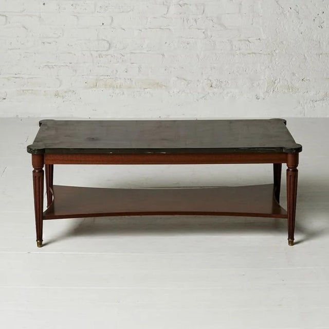 A supremely elegant 19th century Belgian coffee table in the Louis XVI style, pairing a striking original black marble top...