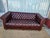 Classic Chesterfield sofa in dark brown leather. This piece has deep button tufting across the back, seat, and rolled...