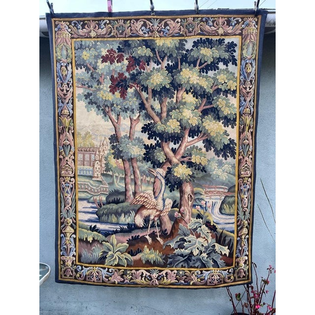 Beautiful French verdure tapestry depicting a charming pastoral landscape, with a bird at the center surrounded by lush...