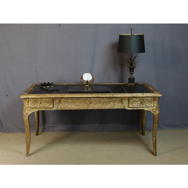 A rare louis xv style desk in wood and gilt stucco, dating from the 19th century. This desk rests on four cabriole legs...