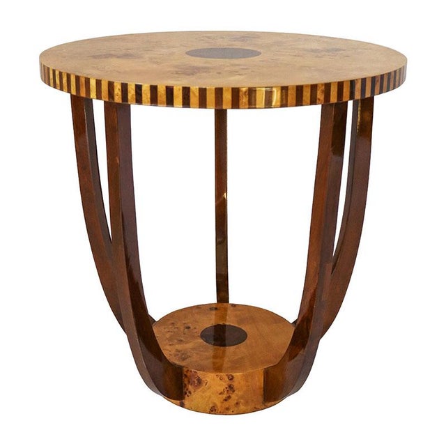 Low round coffee table veneered in birch root and various precious woods, with stepped base where four curved legs are...