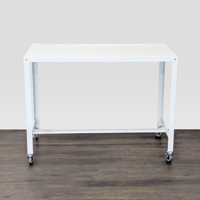 This CB2 desk features a clean white top and sturdy metal frame. It comes with smooth-rolling wheels, making it easy to...
