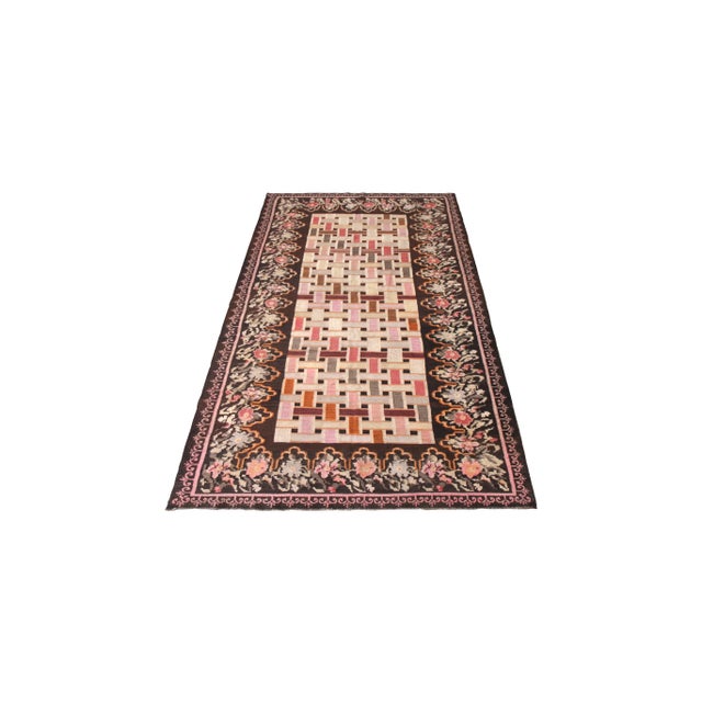 Hand woven in a wool flat weave originating from Turkey circa 1950-1960, this vintage Kilim rug connotes a mid-century...