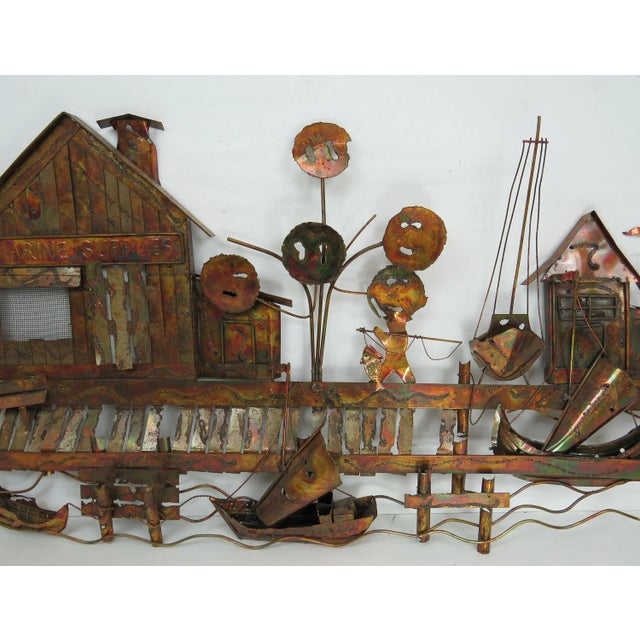 Vintage Curtis Jere style torch cut copper wall sculpture. A rustic boat dock or pier. Scene includes a marine supplies...