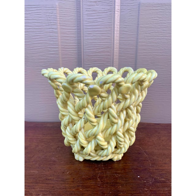An elegant trompe l'oeil porcelain cachepot crafted in the form of a handwoven rope basket. Executed in glossy yellow...
