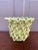 An elegant trompe l'oeil porcelain cachepot crafted in the form of a handwoven rope basket. Executed in glossy yellow...