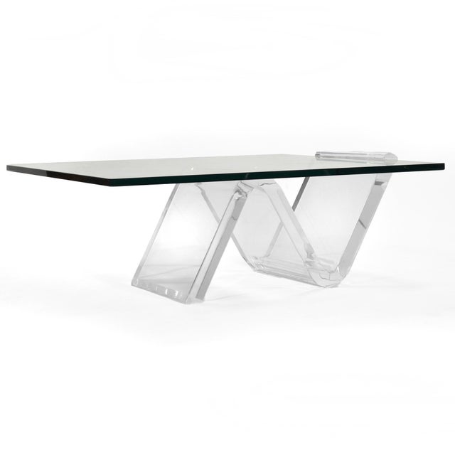 A delightful and dramatic design, this coffee table has a thick glass top cleverly supported and held by the sculptural...