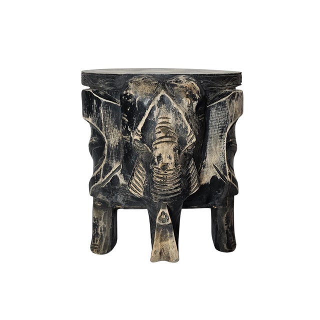 Hand-carved wooden elephant stool, with a distressed or antique finish, as seen in the black and white patina so commonly...