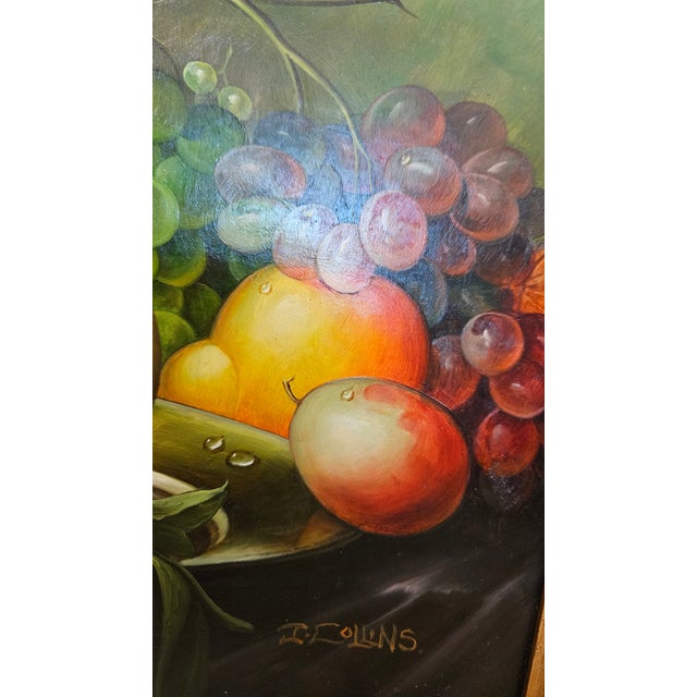 This classic oil painting by J. Collins features a lush still life of fruit, including ripe peaches, grapes, and citrus,...