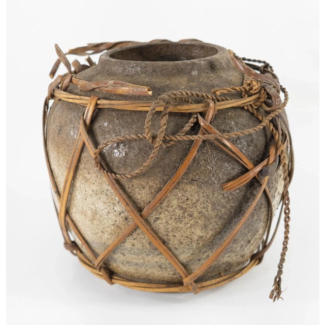 We are offering this simple rustic Chinese crackled porcelain vase with woven reed exterior, heavy patina on the surface...