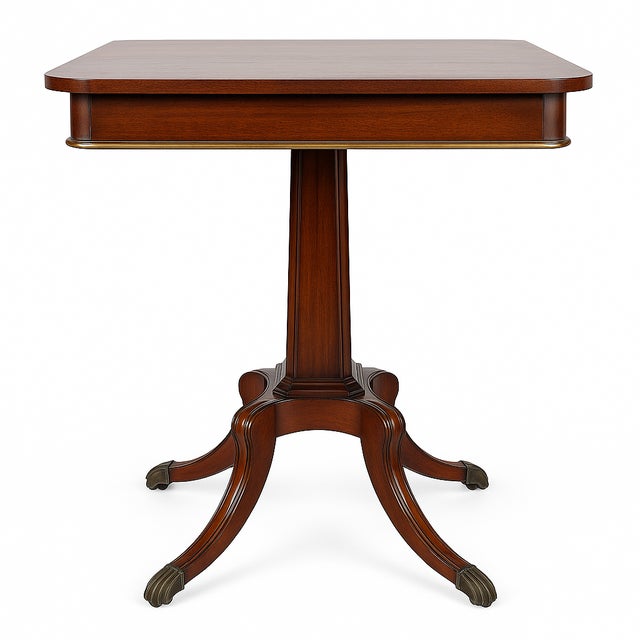 A sophisticated pair of early 20th century Sheraton-style mahogany pedestal side tables featuring rich wood grain, tapered...