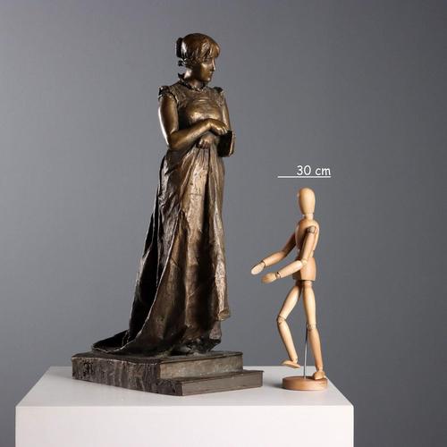 Bronze sculpture depicting a woman with a book. Signature engraved on the side of the base. This piece is attributed to...