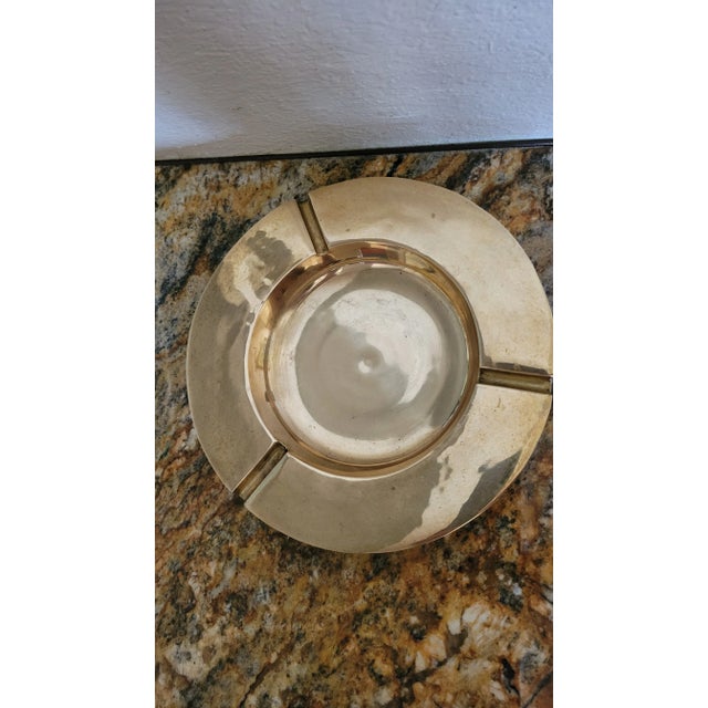 Beautiful round brash ashtray with three cigarrete holders. The piece is solid and fairly heavy.
