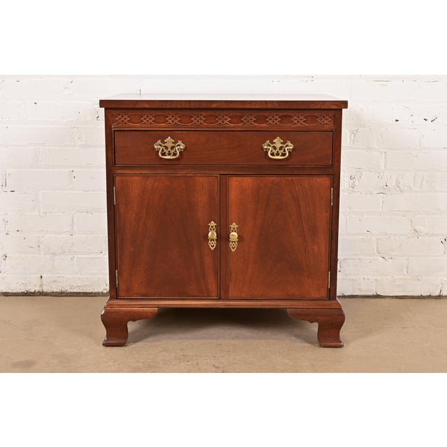 A beautiful Georgian or Chippendale style nightstand or end table By Baker Furniture USA, Circa 1980s Carved mahogany,...