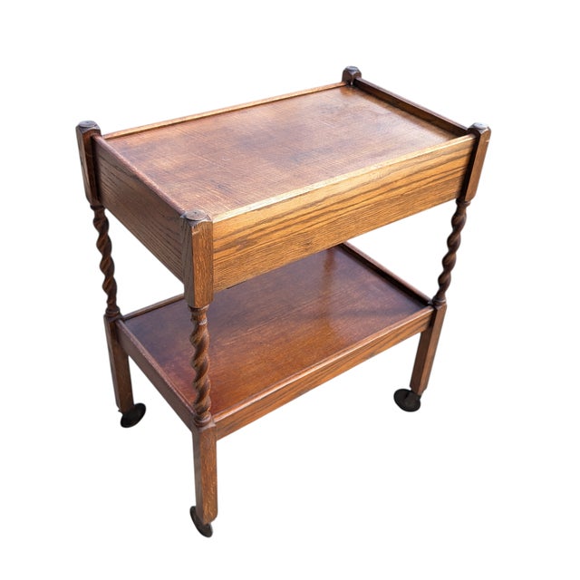 This antique tea cart features a two-tiered design with a single drawer and original casters. Excellent period condition,...