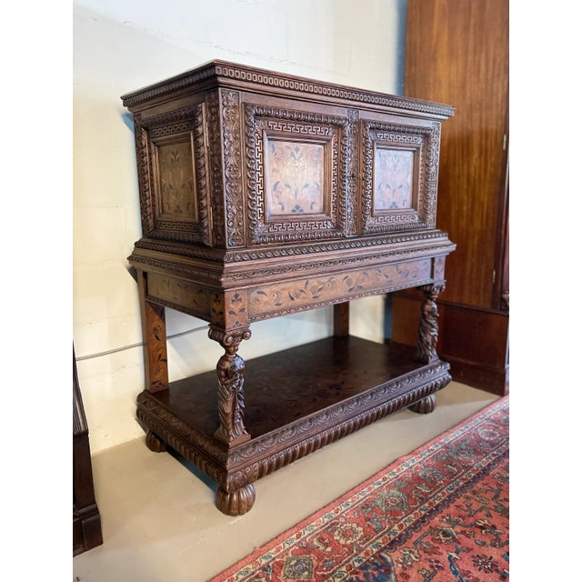 Antique English Oak Renaissance Revival cupboard featuring an original working key, ornate border carvings around the...
