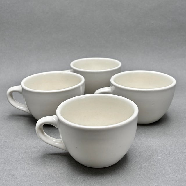 This listing includes a set of four heavy-duty beige ceramic coffee cups featuring a classic, rounded diner style. These...