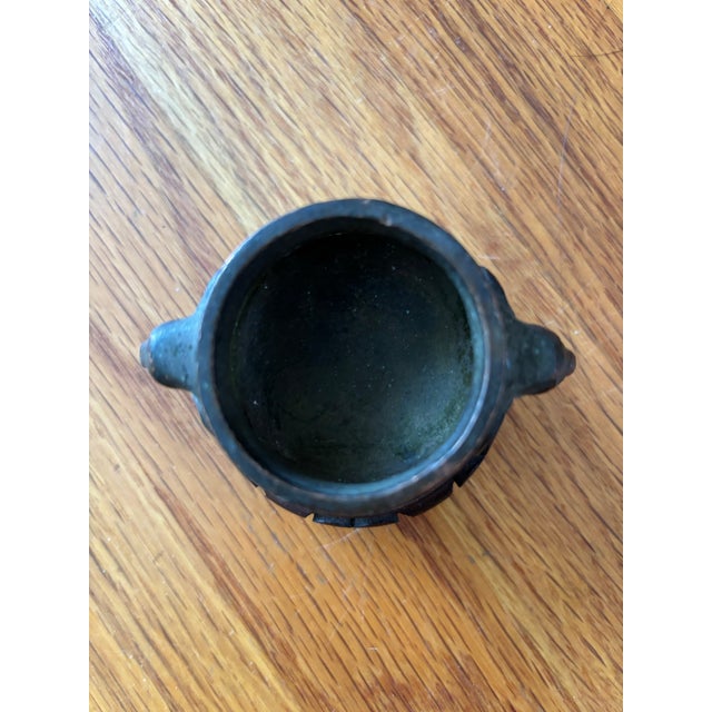An exquisite, small-scale Chinese cast bronze censer featuring an elegant cylindrical body flanked by twin elephant-head...
