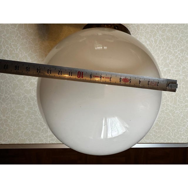 Vintage wall sconce with a modernist design, composed of a white opaline glass globe and a geometric chrome-plated metal...