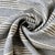 A sophisticated Italian woven stripe featuring a soft neutral gray ground with classic ticking-style stripe detail....