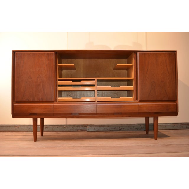 Teak highboard Danish design from the 60s. Solid oak veneered with elegant teak. 4 drawers, 4 sliding doors, 2 shelves on...