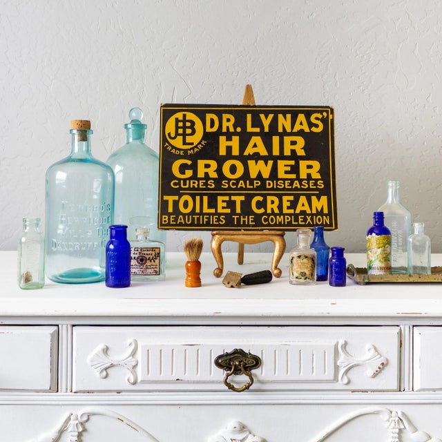 Antique two-tone block relief mustard yellow and black pharmacy sign reads 'Dr. Lyna's Hair Grower - cures scalp disease -...