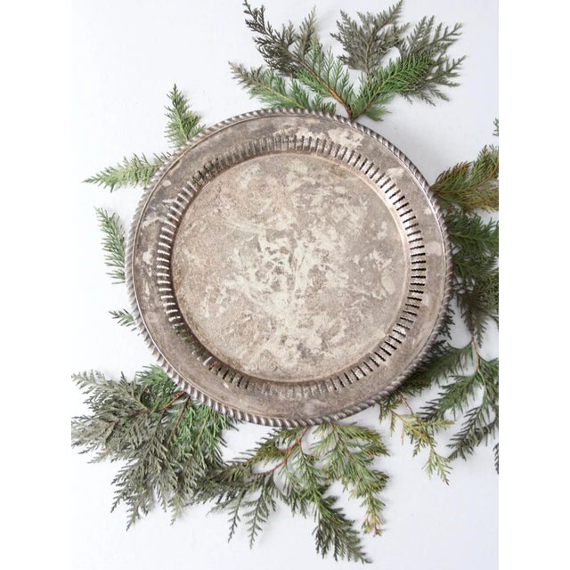 This antique Gotham silverplate copper tray, dating to the early 20th century, features a large round form with an...