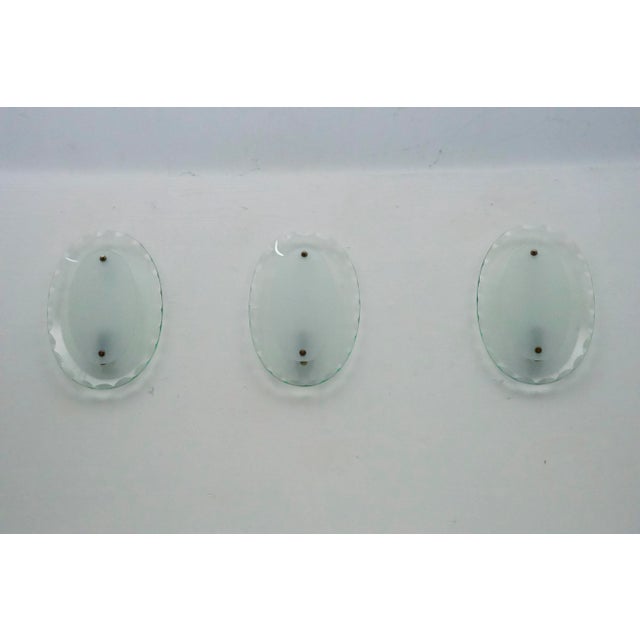 This set of three sconces, crafted by Cristal Art in the 1960s, features elegant curved glass. The pieces are in excellent...