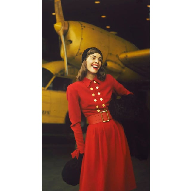 Model in a Red Dress 1959 A fashion shoot featuring a model in a red dress in front of a yellow aeroplane. Toni Frissell...