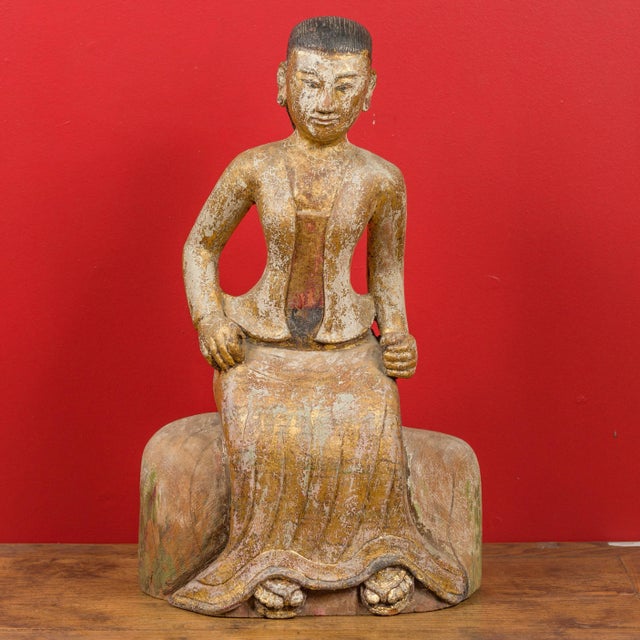 A Burmese hand carved and gilded seated woman statue from the 19th century, in traditional costume. Created in Burma...