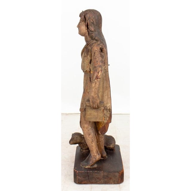 Saint John the Baptist Carved Polychromed Wood Sculpture, early 19th century, holding a scroll and accompanied by a seated...