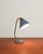 Blue painted metal frame with curved brass stem and adjustable conical diffuser. Ewå branding and "made in sweden" stamped...