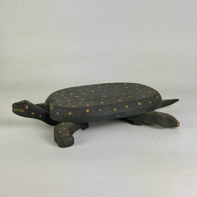 A. most adorable Folk Art turtle. It's been hand carved and assembled then hand painted in hues of mustard yellow, against...