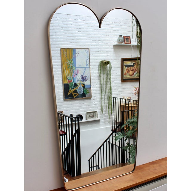Large Mid-Century Italian wall mirror with brass frame (circa 1950s). The mirror is classically-shaped and distinctive in...