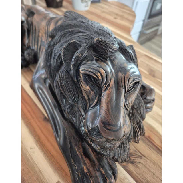 Bring a powerful yet serene focal point to your space with this exceptional mid to late 20th century hand-carved wood lion...