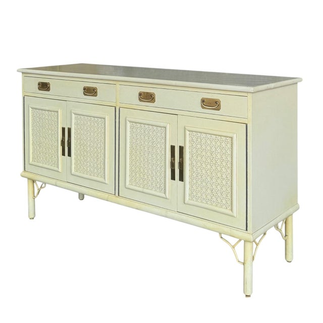 A Palm Beach chic sideboard by Ficks-Reed in a soft, creamy yellow. A laminate top with bamboo banding rests atop two...